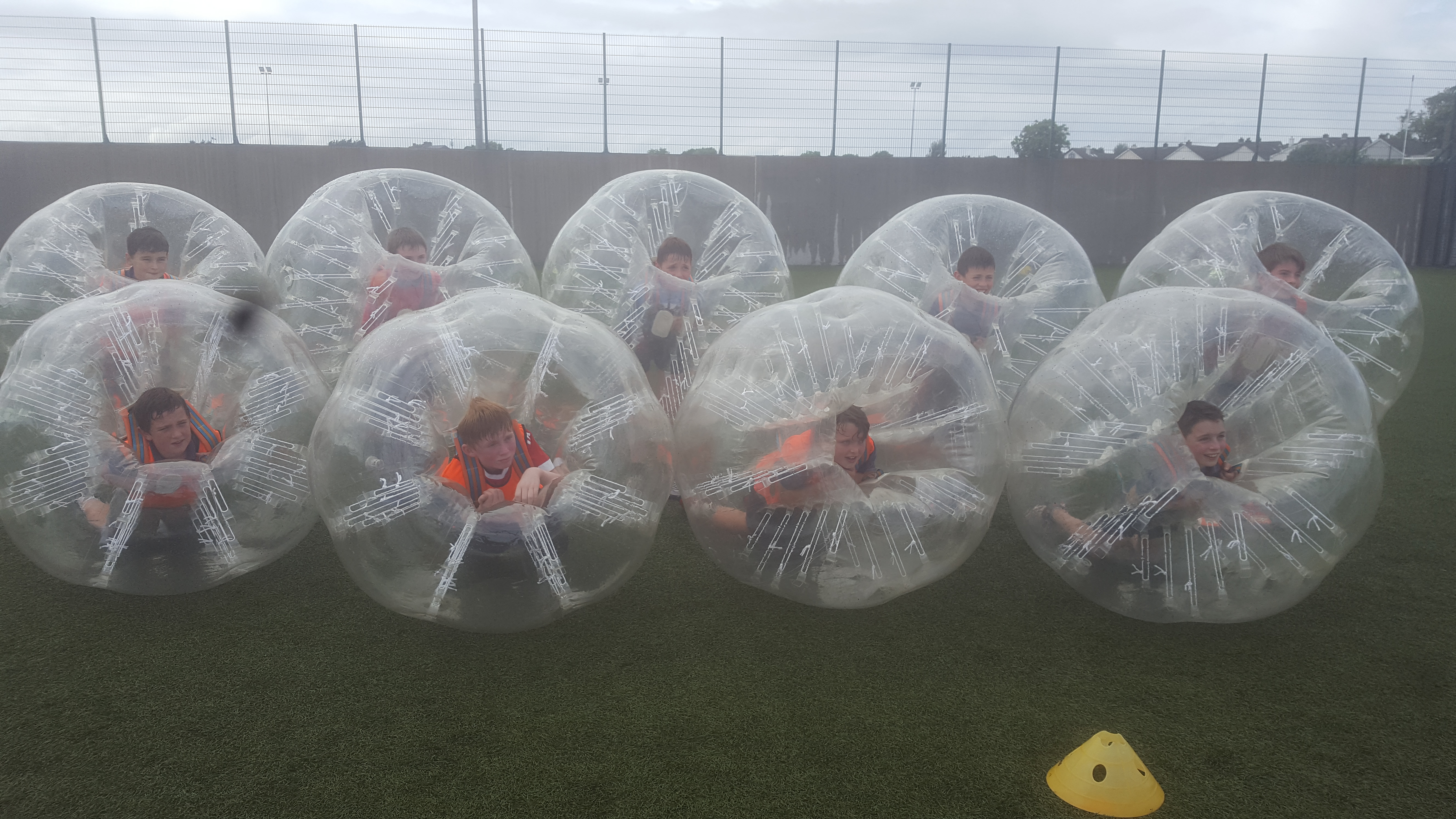 Group of kids in team photo within large Bubble Footballs