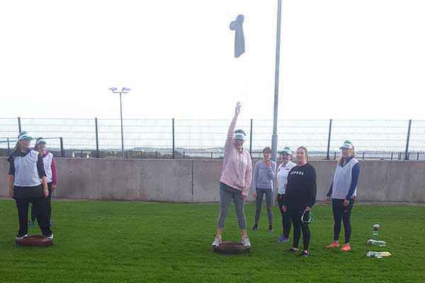 Group ladies on Hen Party playing a game involving throwing a wellington.