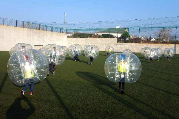Bubble football birthday party with lots of kids on the astro turf pitch