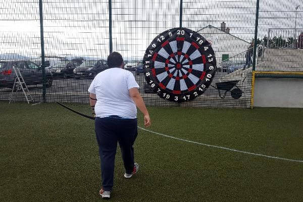 Archery Darts player walking to dartboard on astro surface